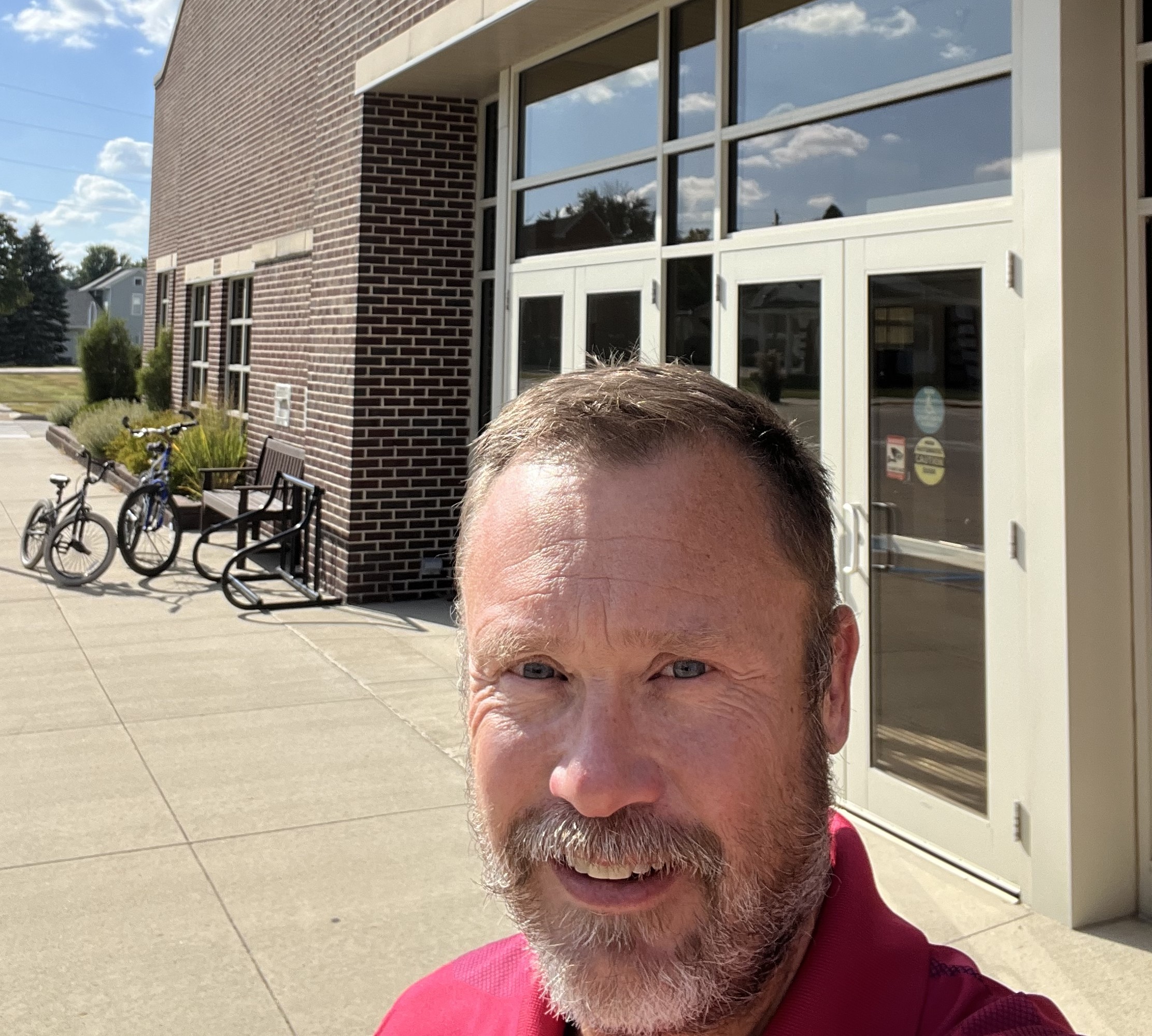 Pibal takes a selfie in front of a brick building.
