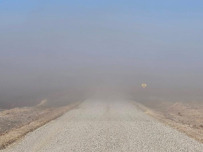 Wind-blown soil reduces visibility on a rural road in Calhoun County during a windy week in February 2026