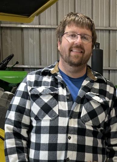 Hepp stands in front of a green tractor.