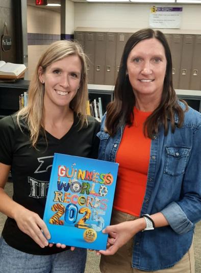 Schwartz and Maulsby stand side by side, holding a copy of Guinness World Records 2025.