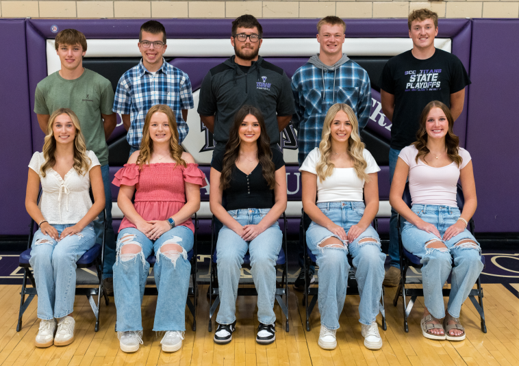 King candidates stand behind the Queen candidates, who are seated.
