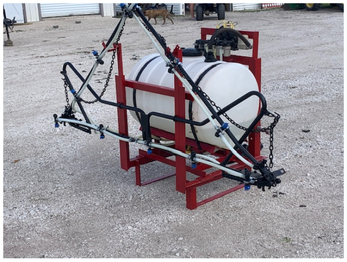 The sprayer consists of a white plastic tank resting inside a red metal frame.
