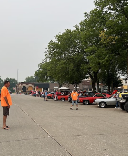A faraway shot of Lake City's Town Square, with cars parked along one side of the street. 