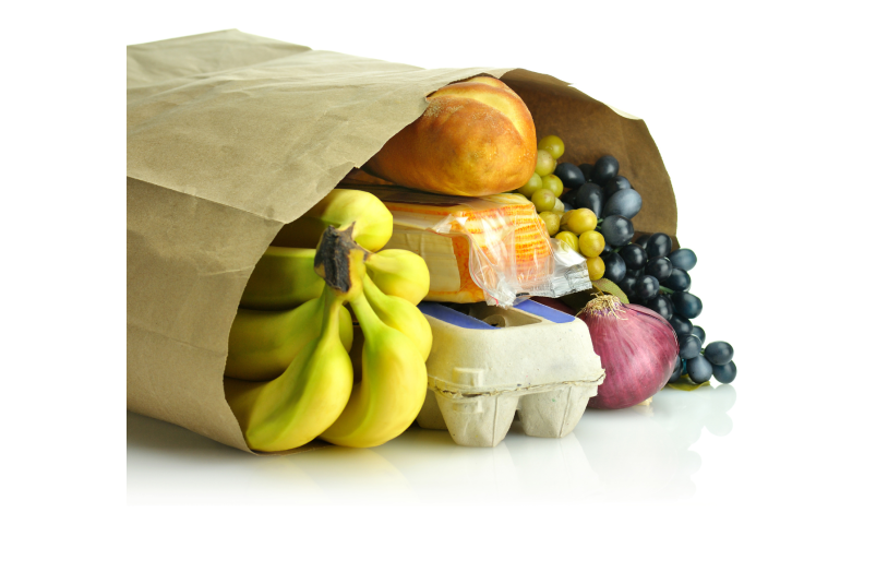 A stock photo of a brown paper grocery bag on its side. Inside the bag are a bunch of bananas, a carton of eggs, purple grapes, an onion, and a loaf of bread.